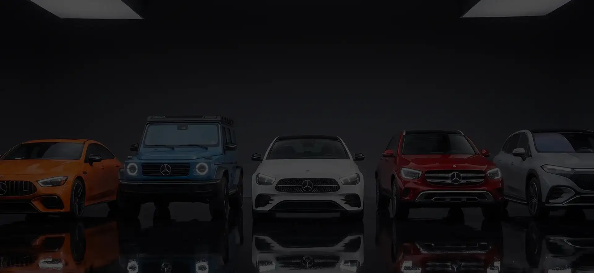 Five Mercedes-Benz models lined up side by side on a reflective black studio floor.