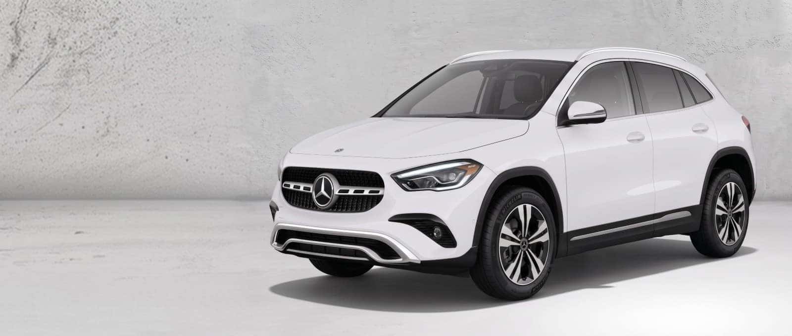 White 2026 Mercedes-Benz GLA 250 4MATIC SUV shown from a front three-quarter angle against a concrete studio wall.