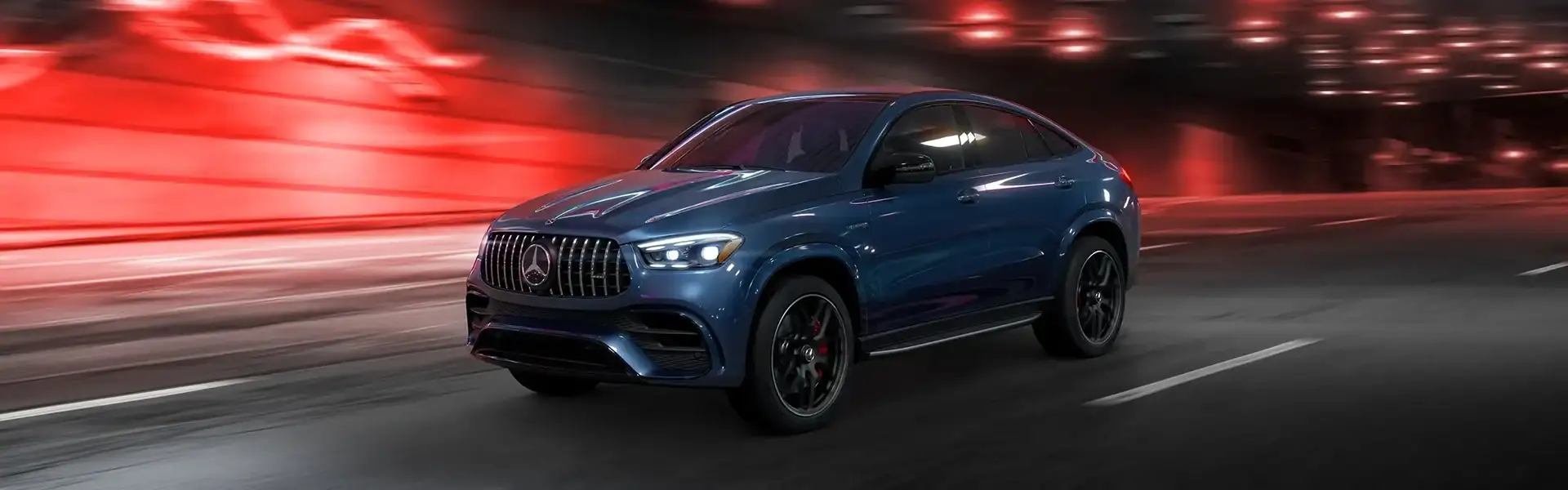A blue Mercedes-AMG GLE Coupe driving through a tunnel, red light streaking past
