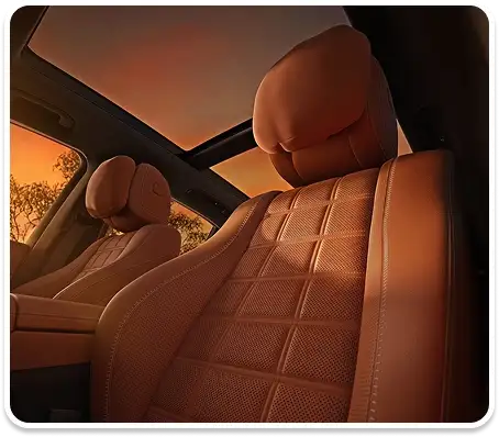 Quilted brown leather seats lit by the sunset through the panorama roof