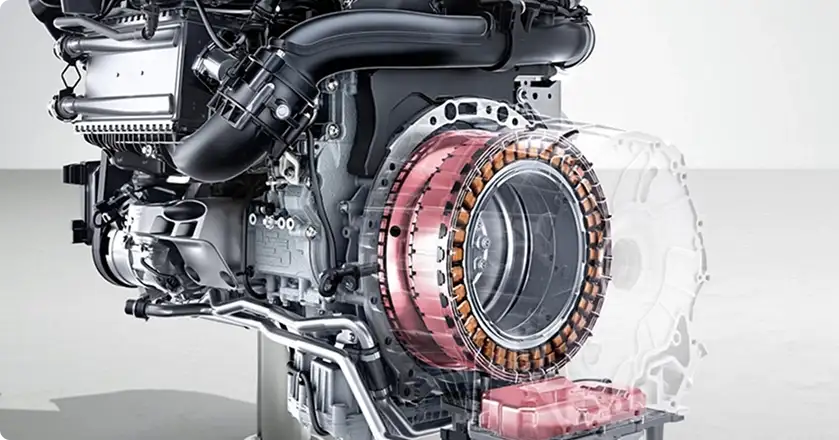 Cutaway inline-4 engine on a stand with its copper starter-generator exposed