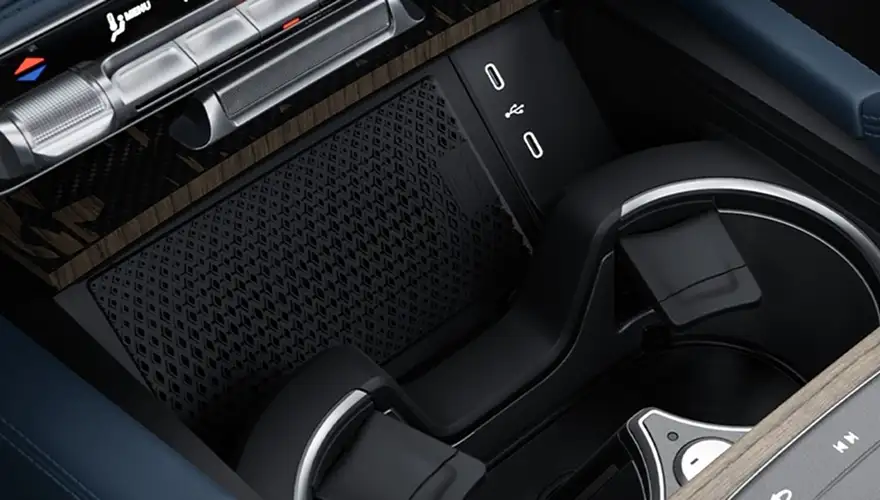 Front console charging tray and cupholders in a dark cabin