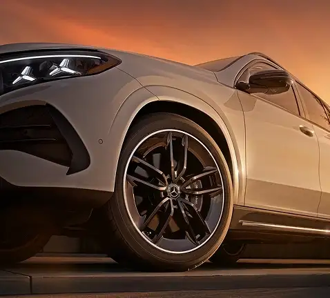 Front wheel and headlamp of a white GLE at sunset