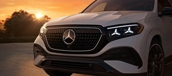 Front of a white GLE with Star-motif headlamps at sunset