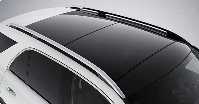 Glass panorama roof and silver roof rails on a white GLE