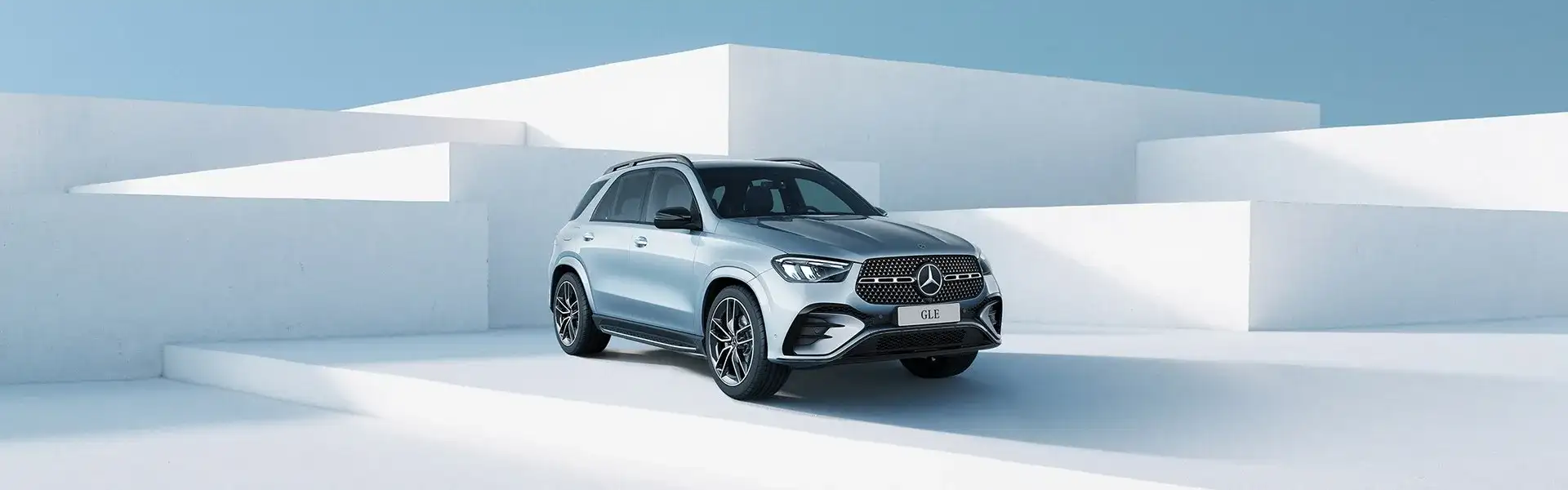 A silver Mercedes-Benz GLE against white architecture