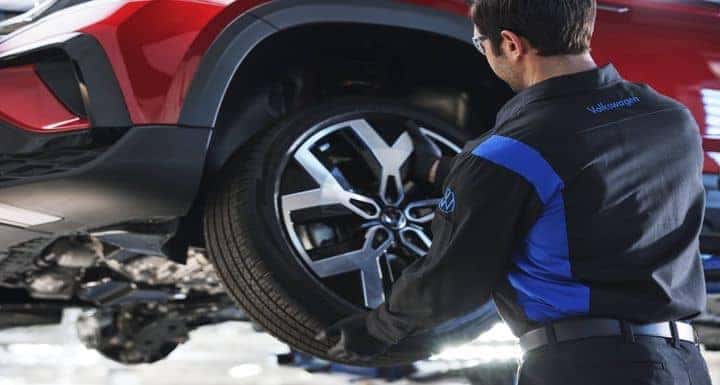 Volkswagen certified technician installing a tire at Herman Cook VW in Encinitas CA