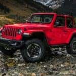 Red Jeep Wrangler parked in the wilderness on a possibly dried up stream bed