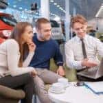 Car salesperson shows couple their used car inventory online
