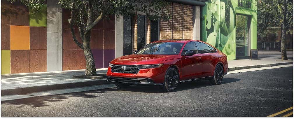 Front three-quarter view of a red 2026 Honda Accord parked on a city street.