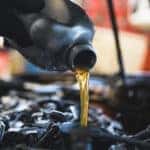 Mechanic changing oil in car