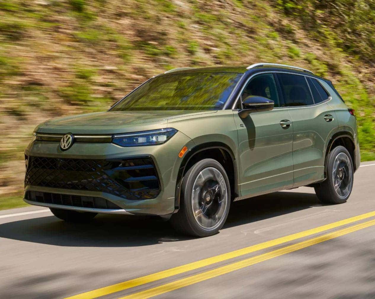2026 Volkswagen Tiguan SUV driving on a sunny road.