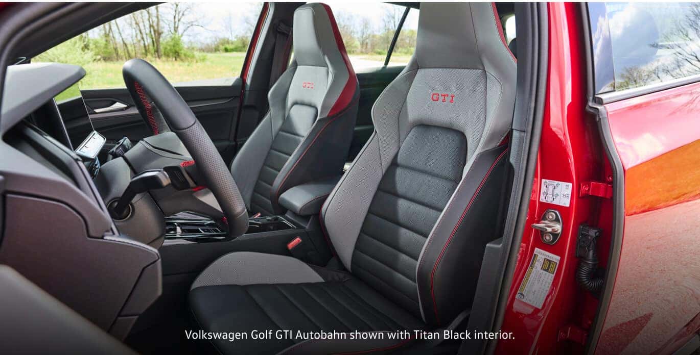 Titan Black interior of a 2026 Volkswagen Golf GTI Autobahn featuring sport seats with red stitching.