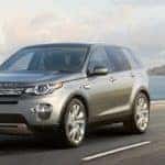 2019 Land Rover Discovery Sport in gray driving on coastal highway with led adaptive headlights