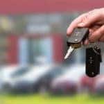 Man holding keys in front of dealership