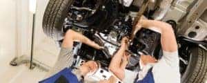 Two mechanics under car in service center