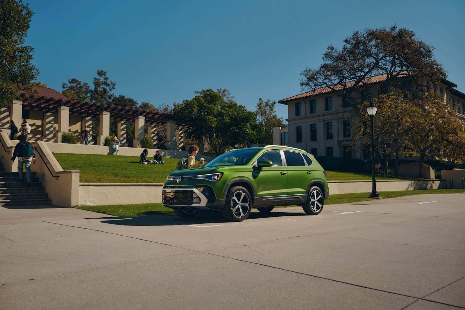 2026 Volkswagen Taos SEL in Bright Moss Green with college students and university buildings in Orangeburg SC, serving SCSU and Claflin University students