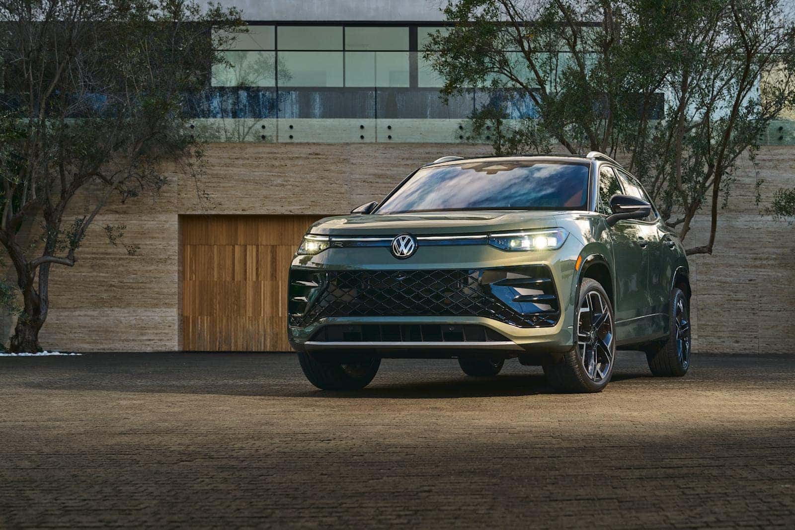2026 Volkswagen Tiguan SEL R-Line in Avocado Green Metallic parked outside a modern luxury estate in Blythewood SC, serving Cobblestone Park and Midlands drivers