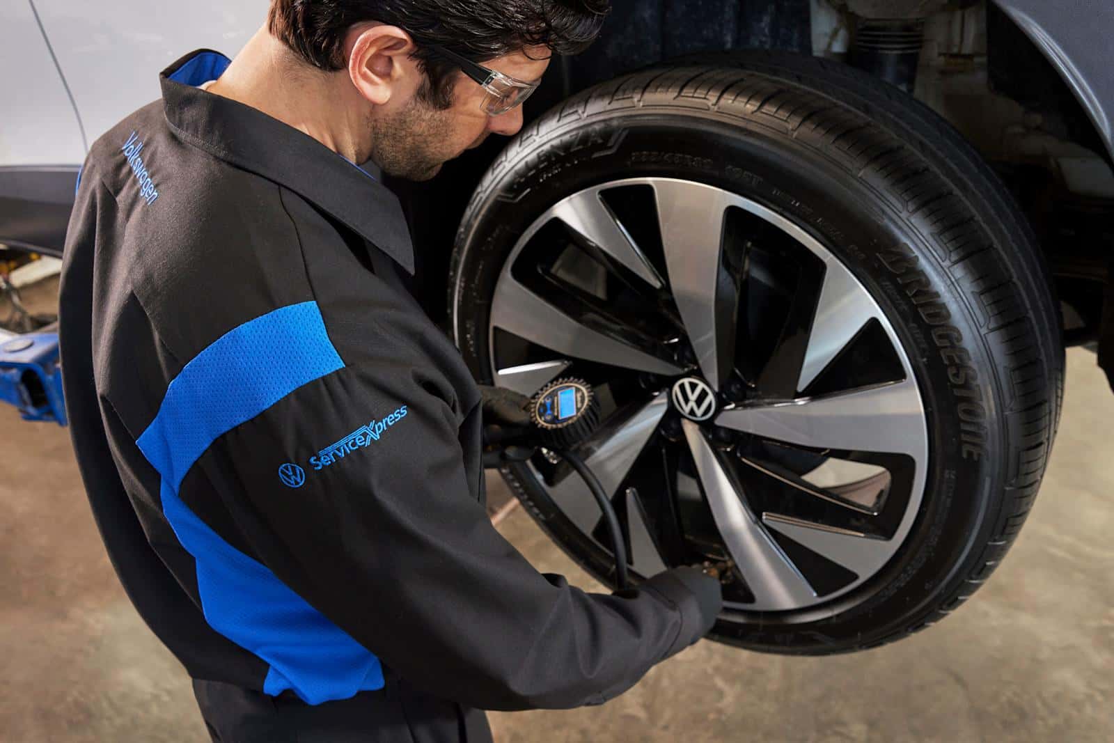 Certified Volkswagen Service Xpress Master Technician inspecting tire pressure, mounting, and balancing at Midlands Volkswagen in Columbia SC