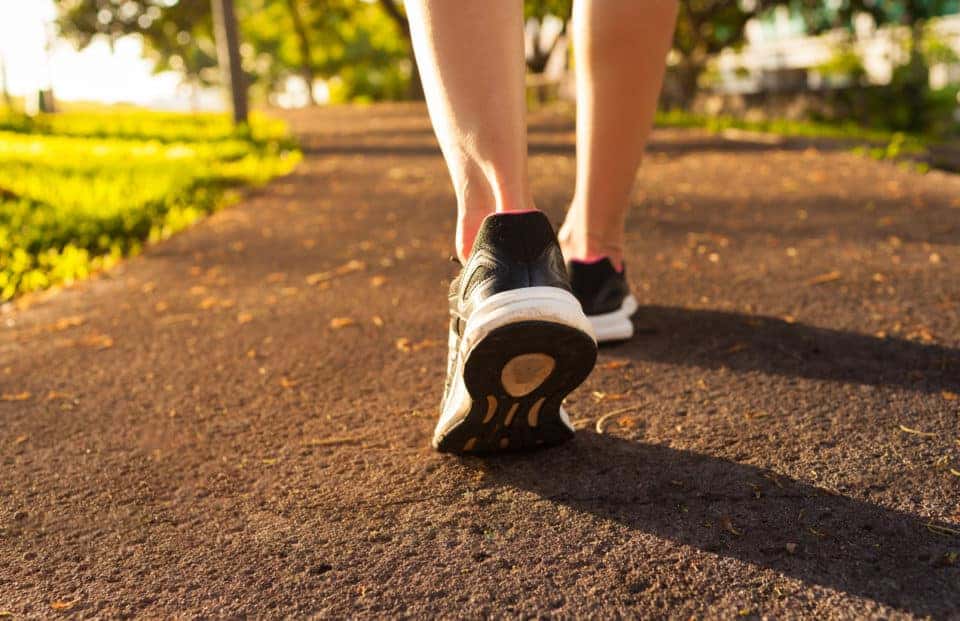 Woman walking outside on a trail.