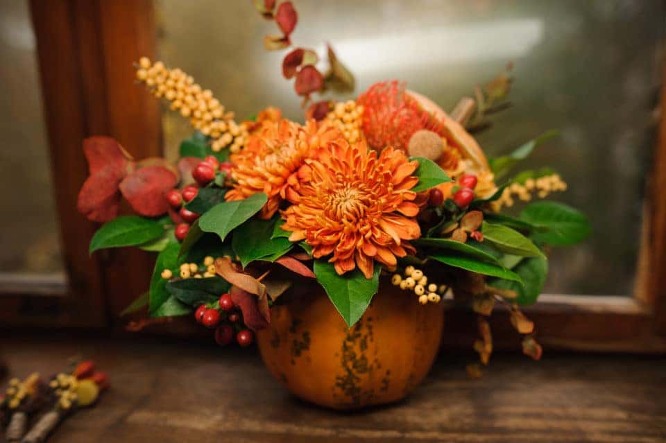 Pumpkin with a beautiful bouquet of autumn flowers inside