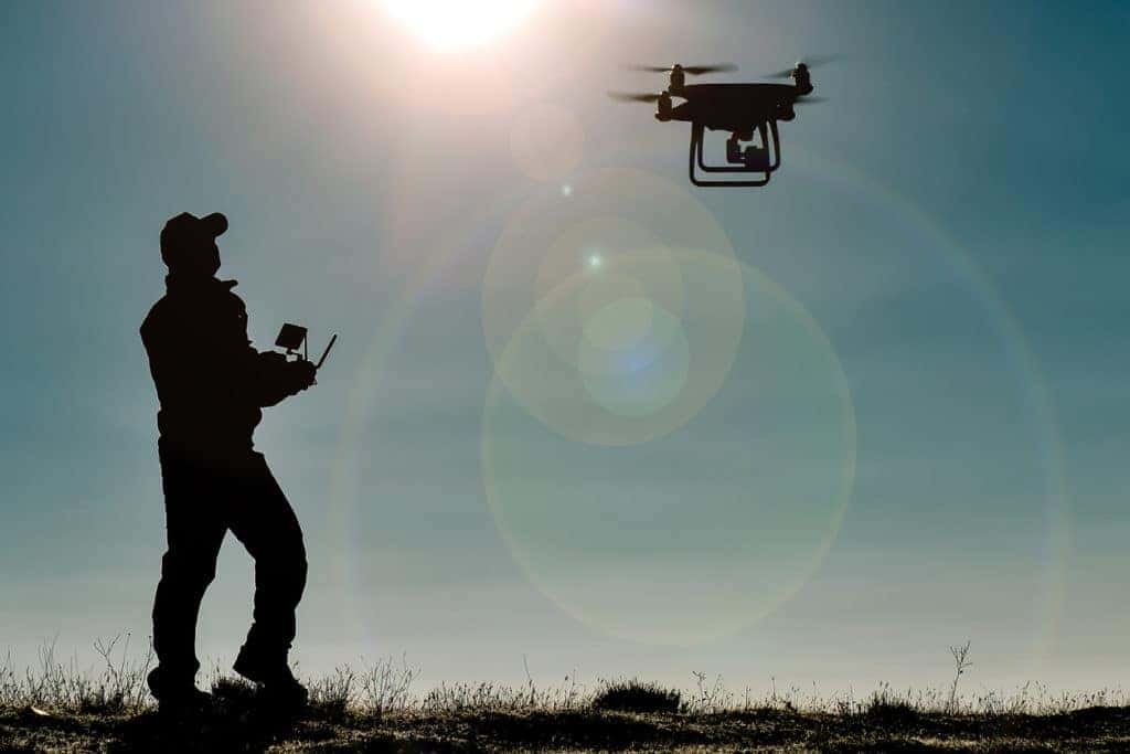 silhouette of man flying drone