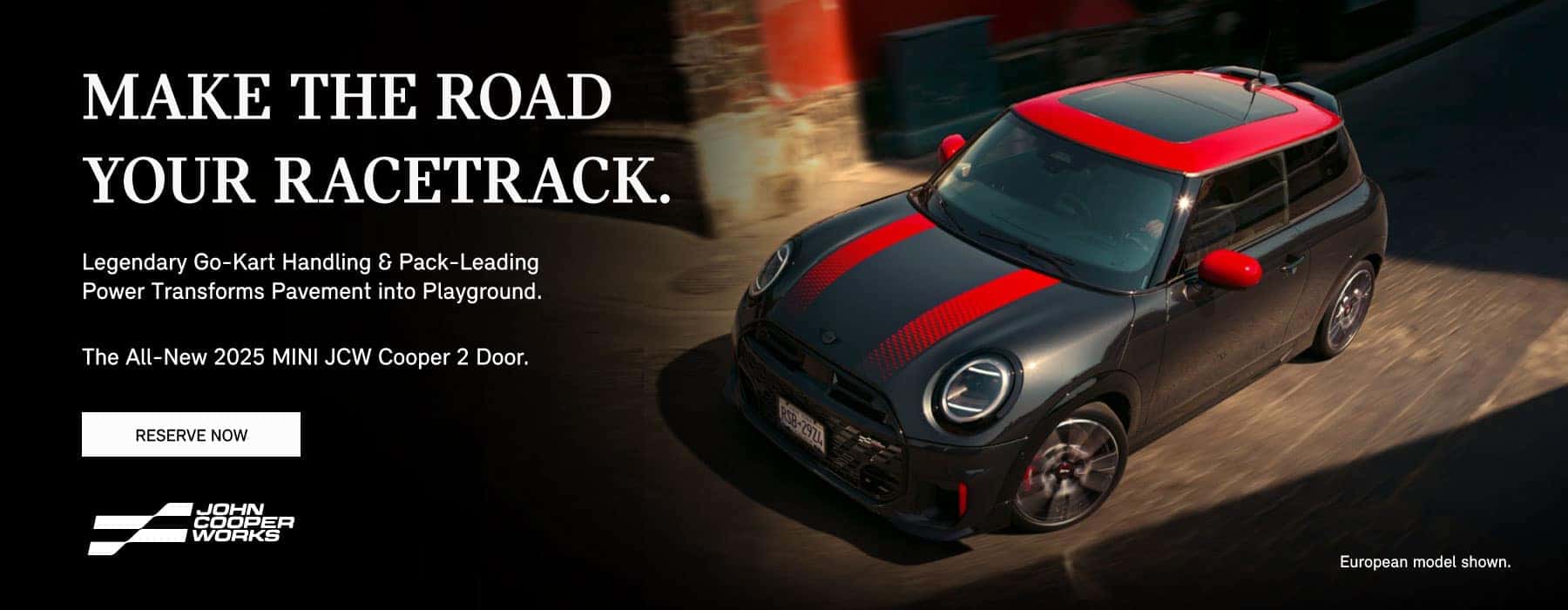 ¾ right view of a black MINI JCW 2 Door with red stripes on a city street.