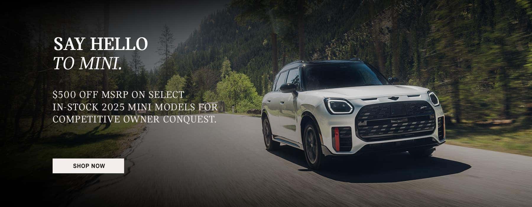 White Countryman JCW driving down a country road.