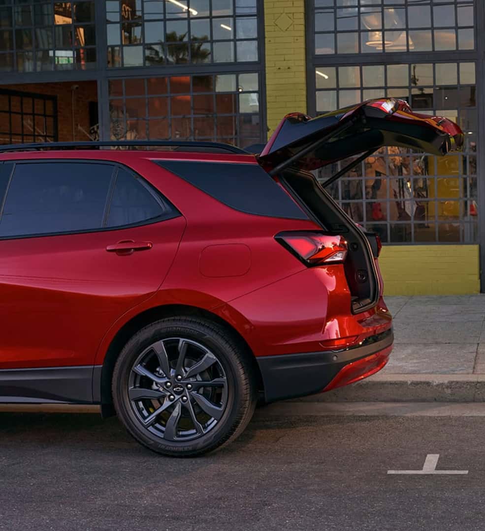 Rear-end of a red 2024 Chevy Equinox RS with tailgate open.