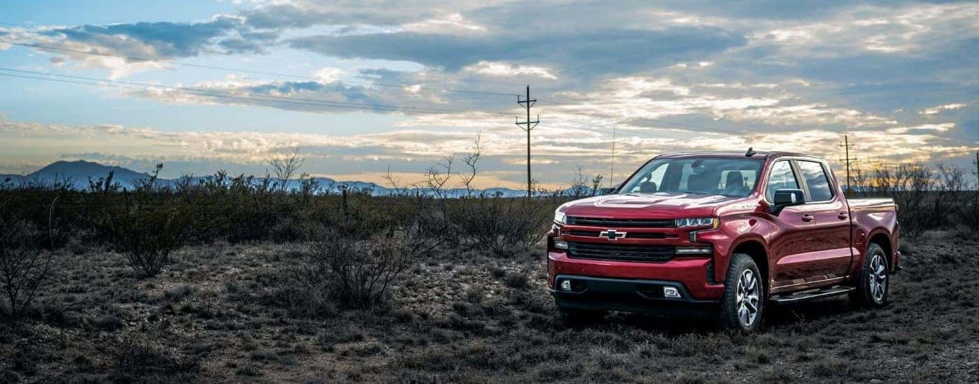 A red 2023 Chevy Silverado 1500 for sale near Mechanicsville parked in an open field.