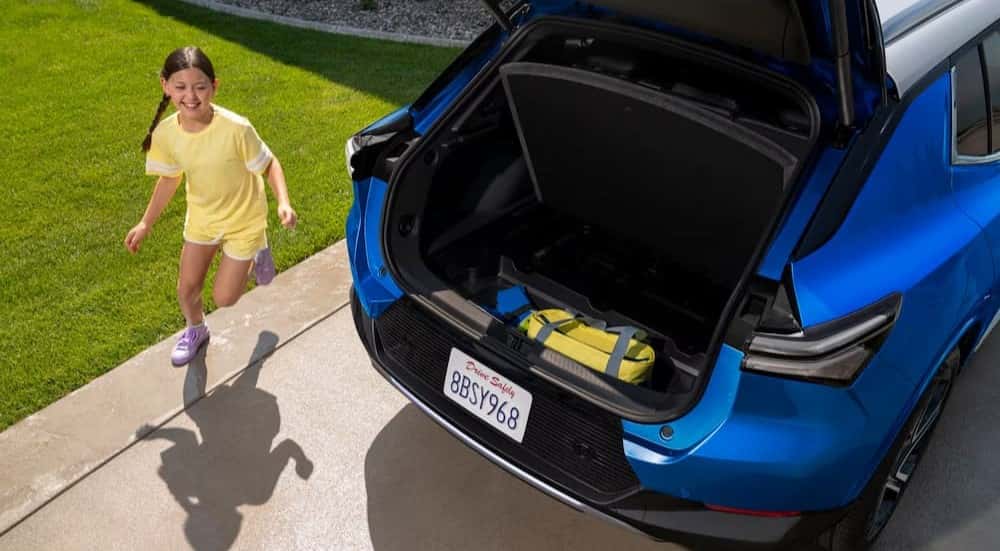 The open hatch is shown on a blue 2025 Chevy Equinox EV.