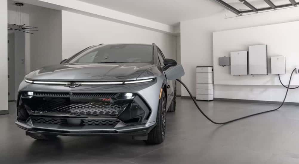A gray 2025 Chevy Equinox EV for sale is shown charging.