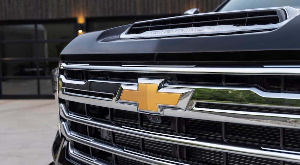 The grille of a black 2025 Chevy Silverado 2500 HD High Country is shown in close-up.