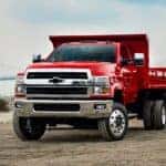 A red 2025 Chevy Silverado 4500 for sale is shown parked on a construction site.