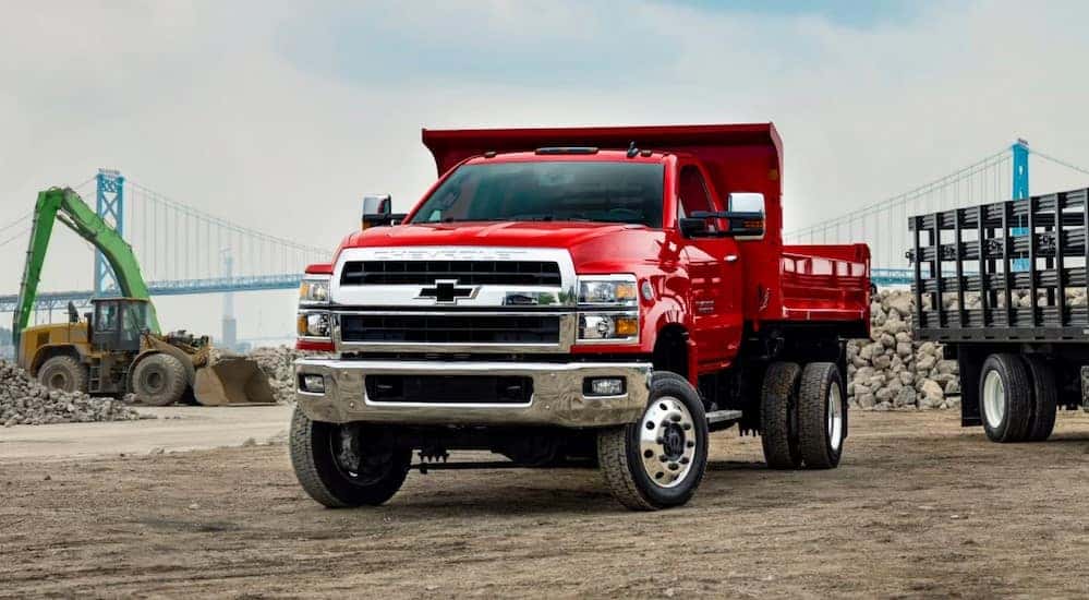 A red 2025 Chevy Silverado 4500 for sale is shown parked on a construction site.