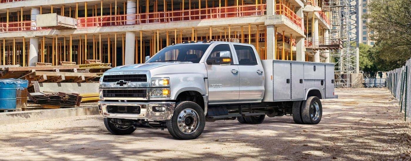 A silver 2020 Chevy Silverado 4500 HD Chassis Cab is shown at a construction site.
