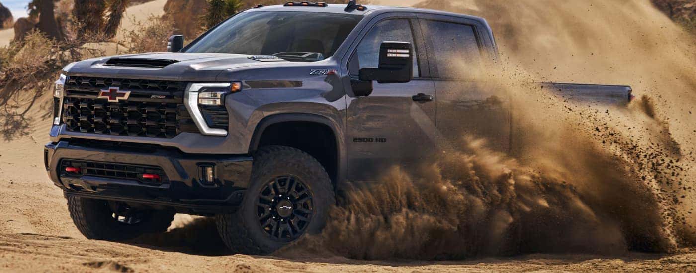 A gray 2025 Chevy Silverado 2500 off-roading in sand