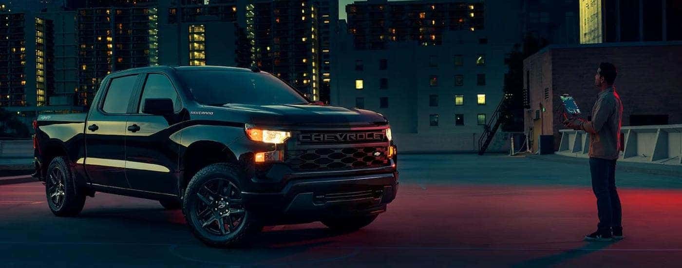 A black 2023 Chevy Silverado 1500 Custom is shown from the front at an angle.