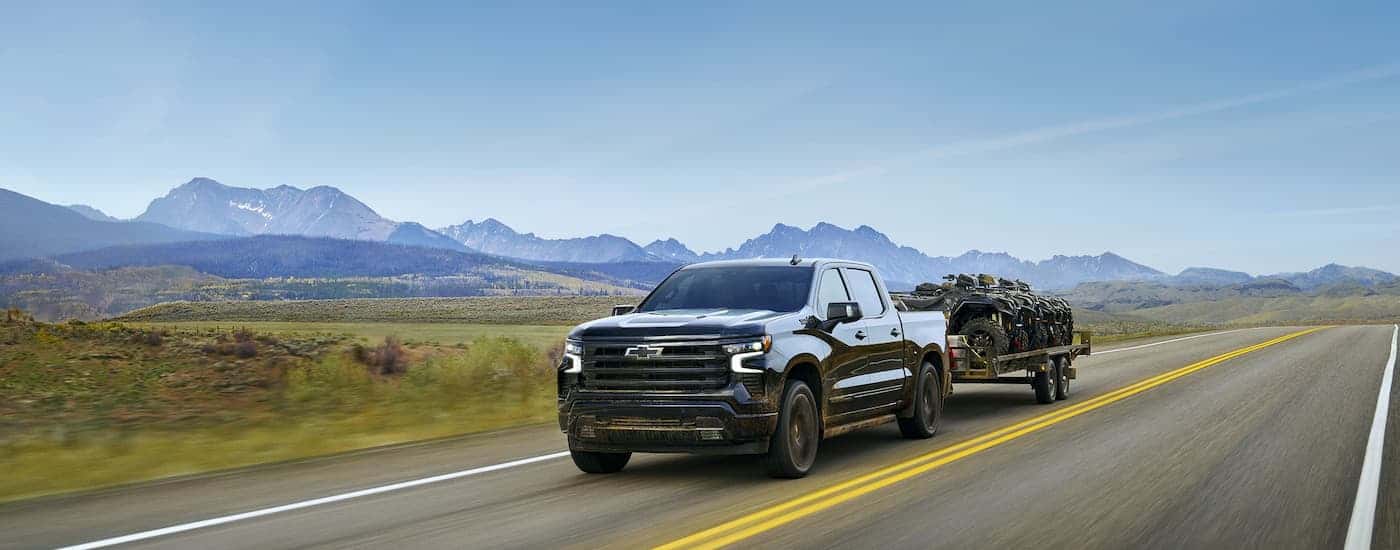 Black 2025 Chevy Silverado 1500 High Country driving on an open road