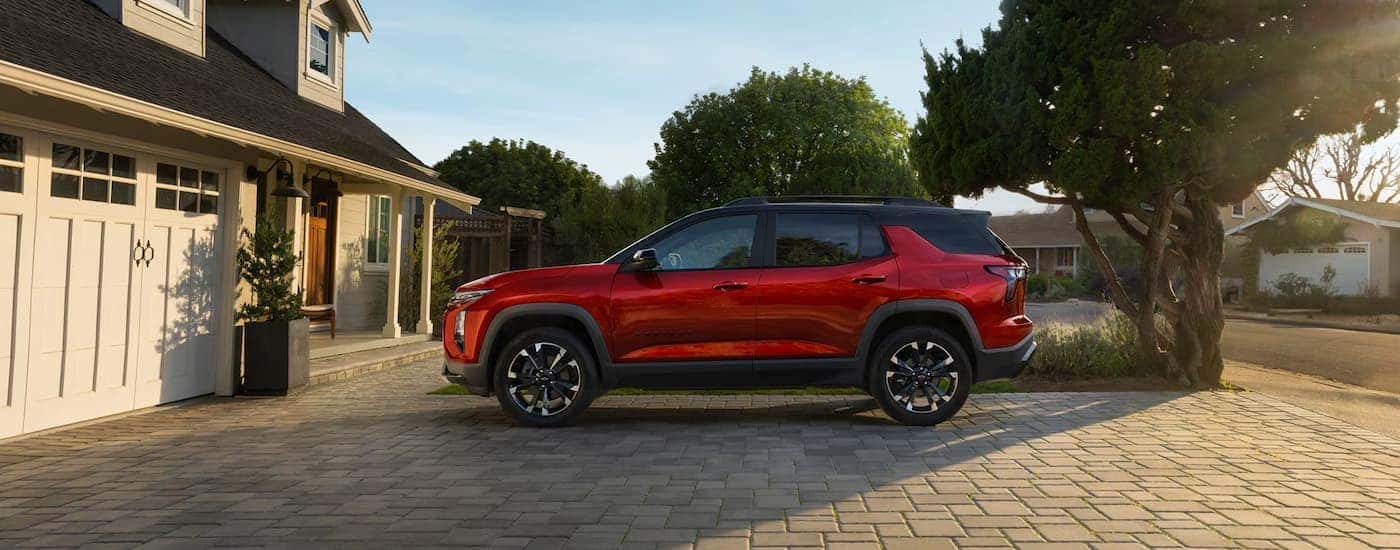 Side of a red 2025 Chevy Equinox RS parked in a driveway