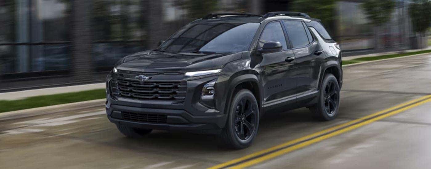 Black 2025 Chevy Equinox Midnight driving on a highway