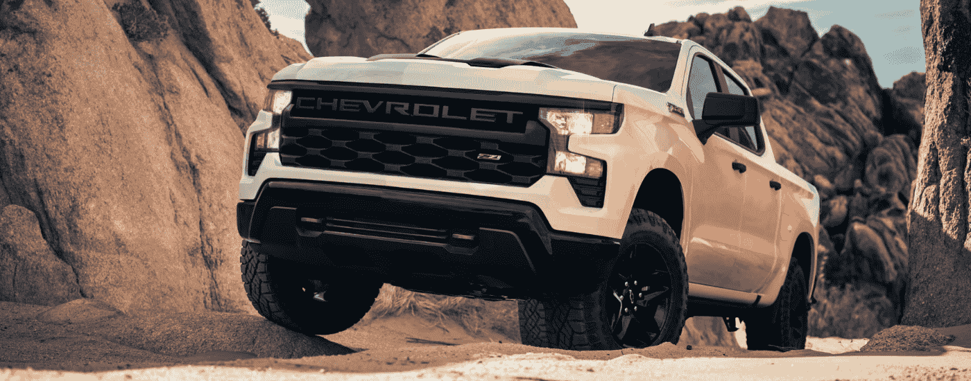 White 2025 Chevy Silverado 1500 Z71 off-roading on a rocky trail