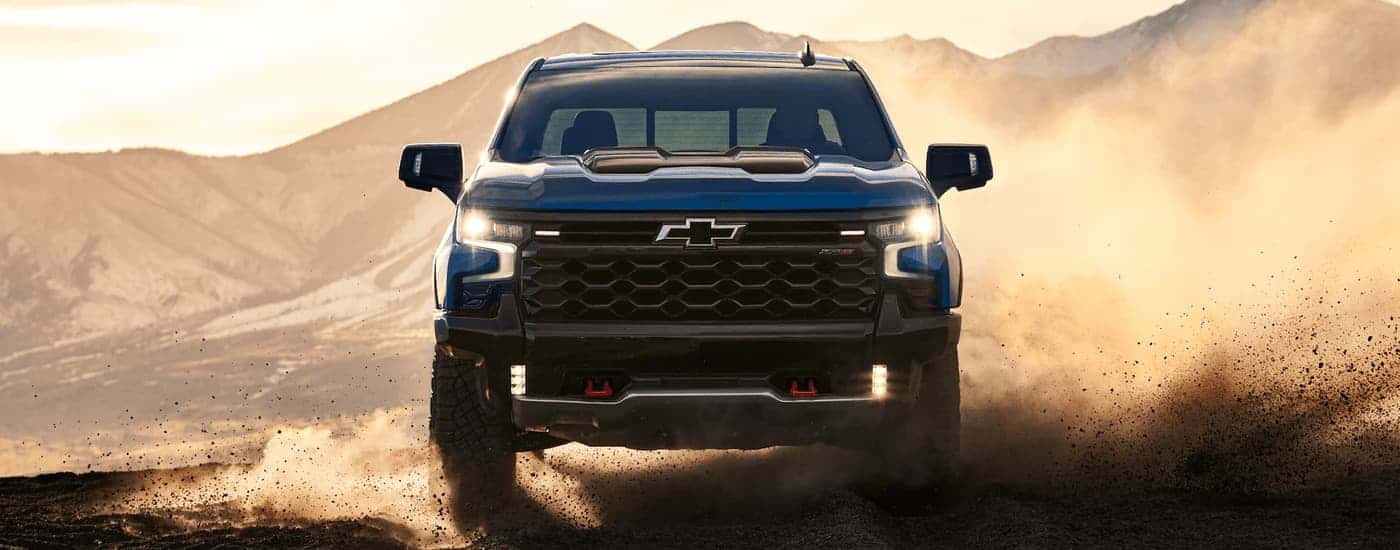 Blue 2023 Chevy Silverado 1500 ZR2 off-roading on a dusty desert path