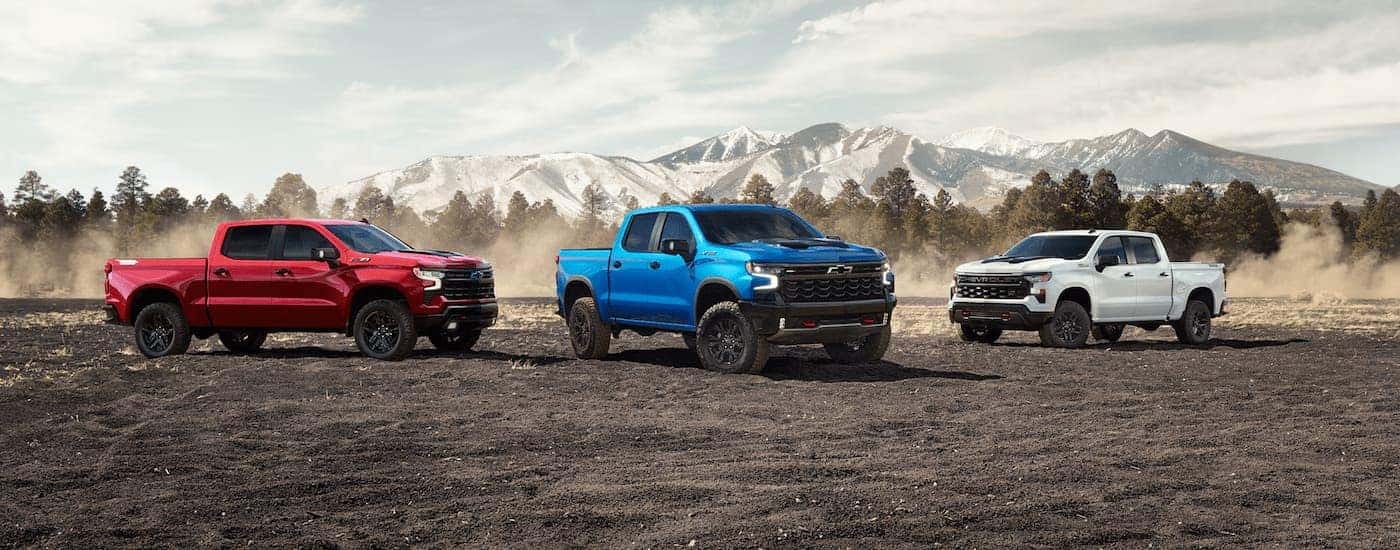 Three 2025 Chevy Silverado 1500 parked on gravel