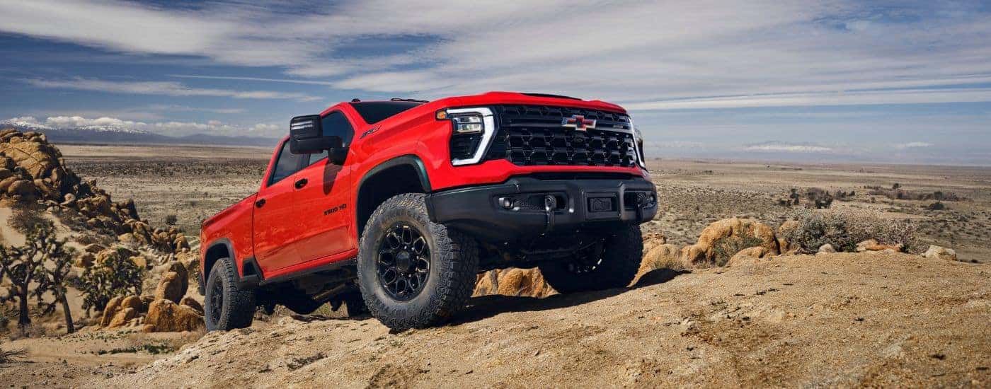 Red 2025 Chevy Silverado 2500HD ZR2 Bison off-roading on a dirt road