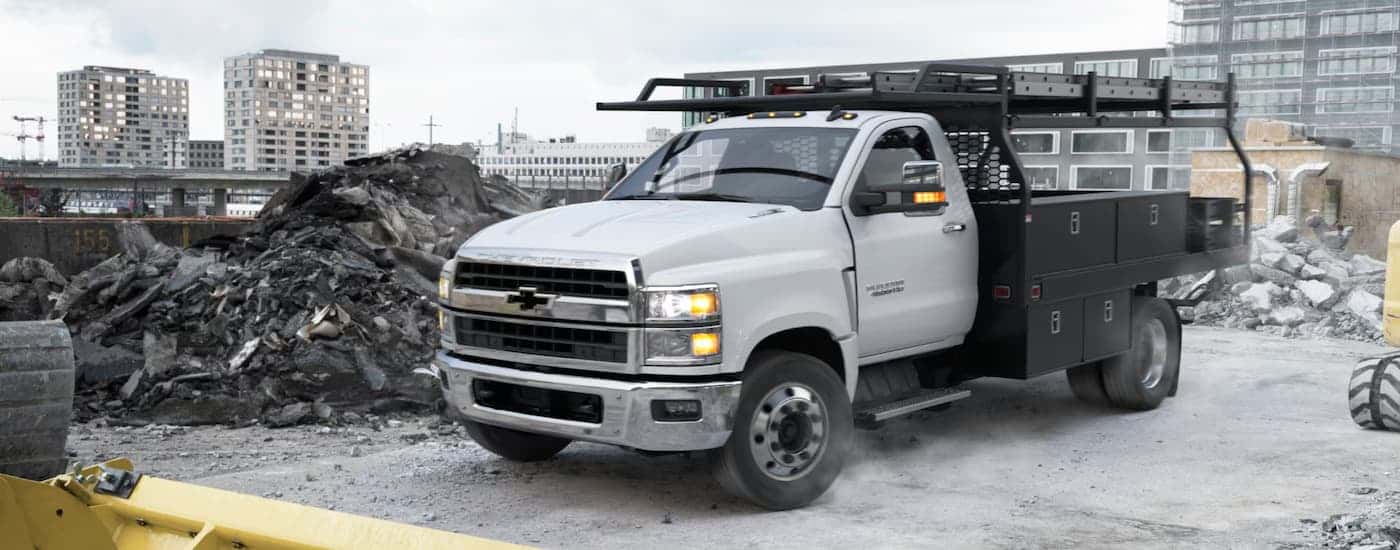 A grey 2024 Chevy Silverado 4500 for sale is shown at a construction site.