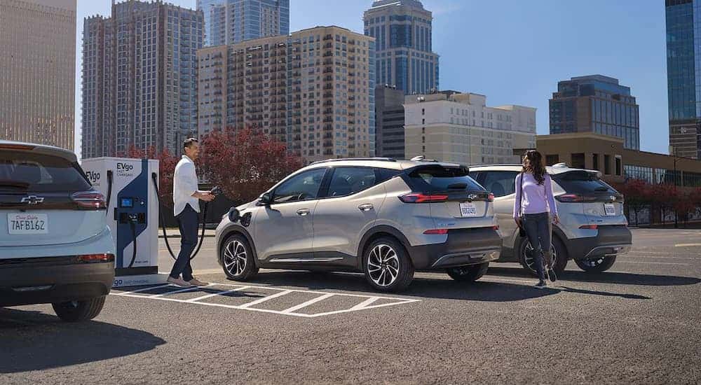 Silver 2023 Chevy Bolt EV parked in a lot and charging