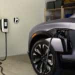 A silver 2025 Chevy Blazer EV for sale is charging in a garage.