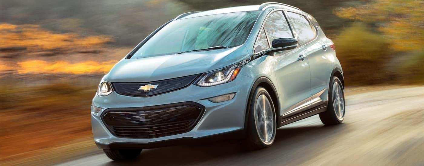 Blue 2017 Chevy Bolt EV driving to look at EVs for sale near Fredericksburg.