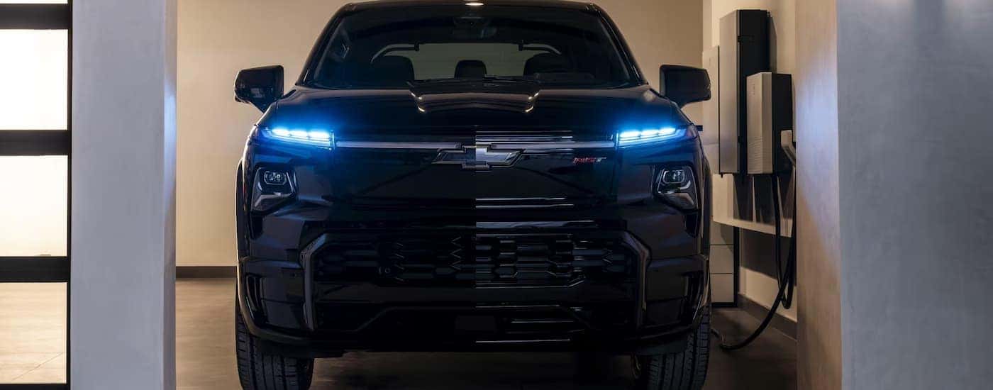 A black 2025 Chevy Silverado EV charging in a garage for sale near Highland Springs